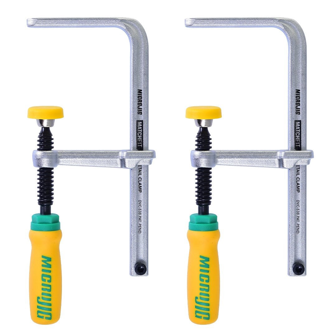 Two MicroJig MatchFit Dovetail Track Clamps with soft grip handles on wood surface
