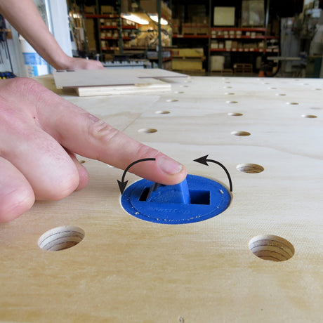 FastCap Blue Dog Bench Dogs in use on a workbench with a wooden surface