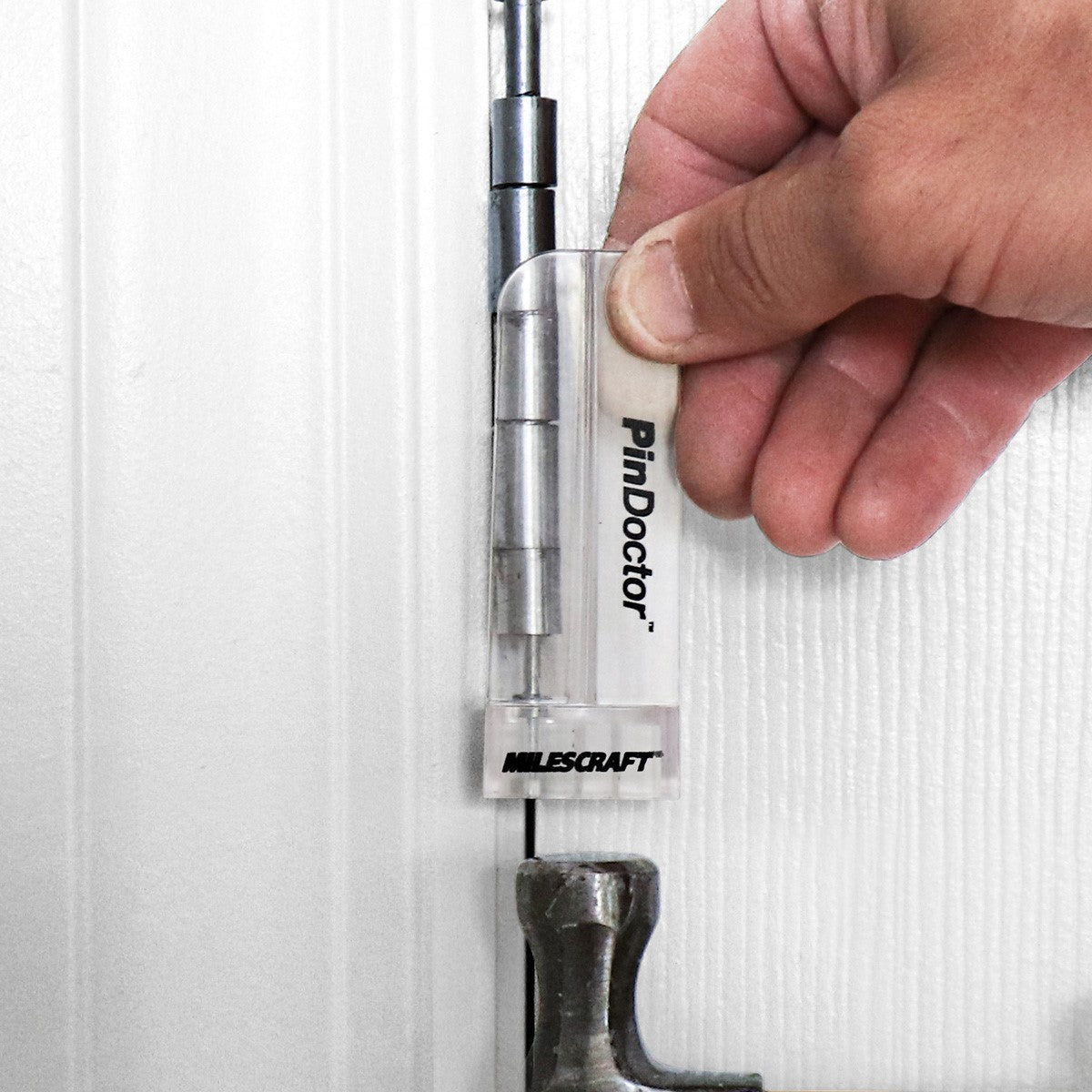 Milescraft PinDoctor tool demonstrating hinge pin removal and installation on a door