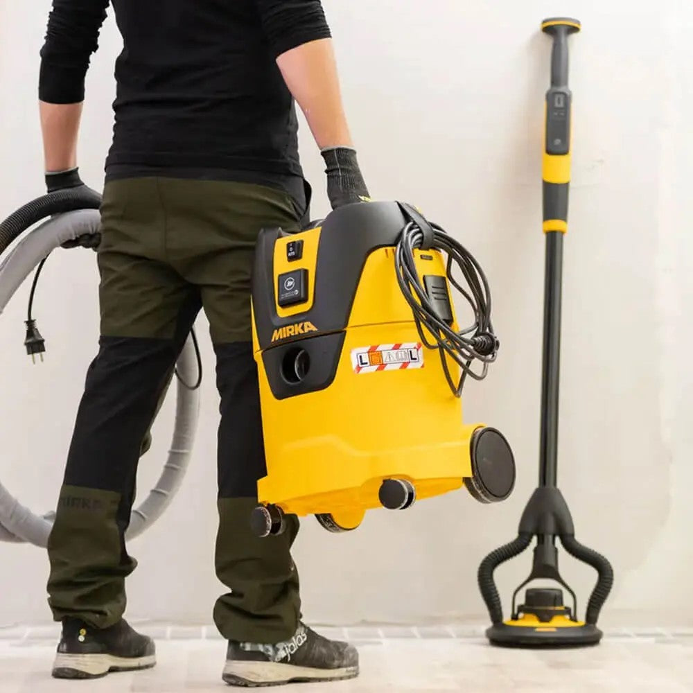 Mirka Dust Extractor 1125 L PC in woodshop setting with hose attached