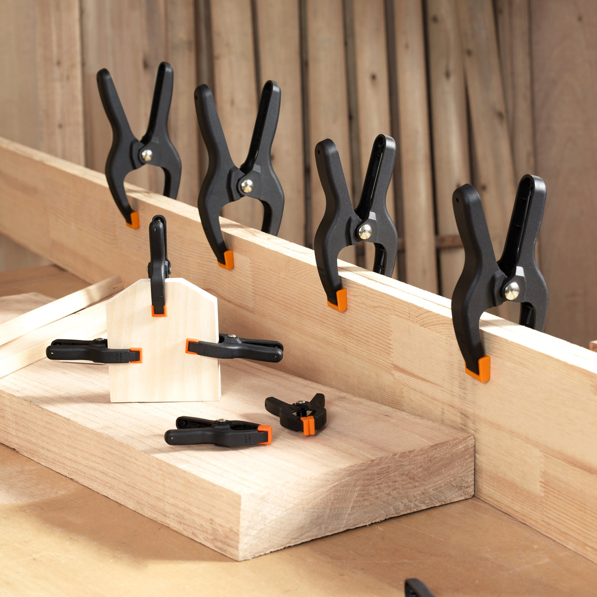 Pony Jorgensen Set of 14 Plastic Spring Clamps with Pivoting Jaw Pads in 19-76mm sizes, ideal for instant clamping in woodworking