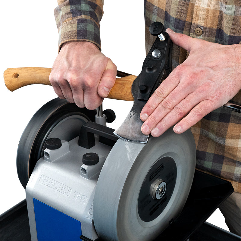 Tormek AX-40 Axe Jig in use, demonstrating precise axe sharpening with composite jaws and adjustable stops