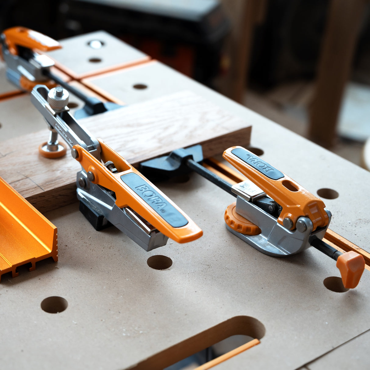 BORA Tool Dog Hole Auto Adjust Toggle Clamp in use on workbench with 19mm bench dog post securely gripping hole