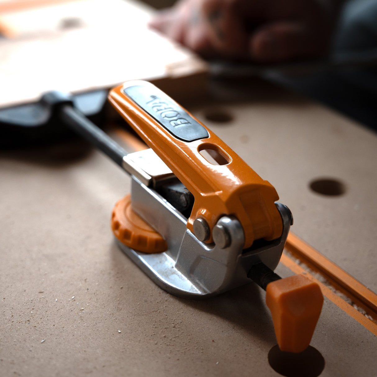 BORA Tool Dog Hole Auto Adjust Inline Toggle Clamp in use on a workbench