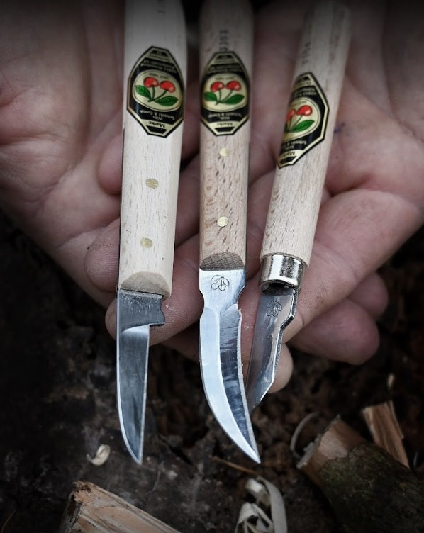 Three carving knives with wooden handles on a natural background