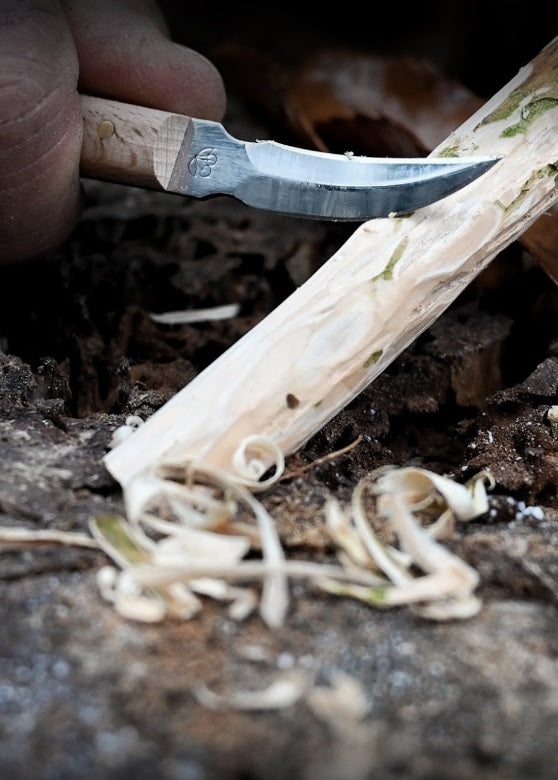 Person using a Carving knife with wooden handle on a natural background