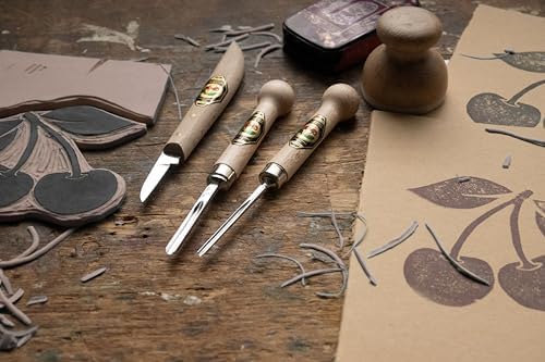 Wooden carving tools on a wooden surface with carved designs.