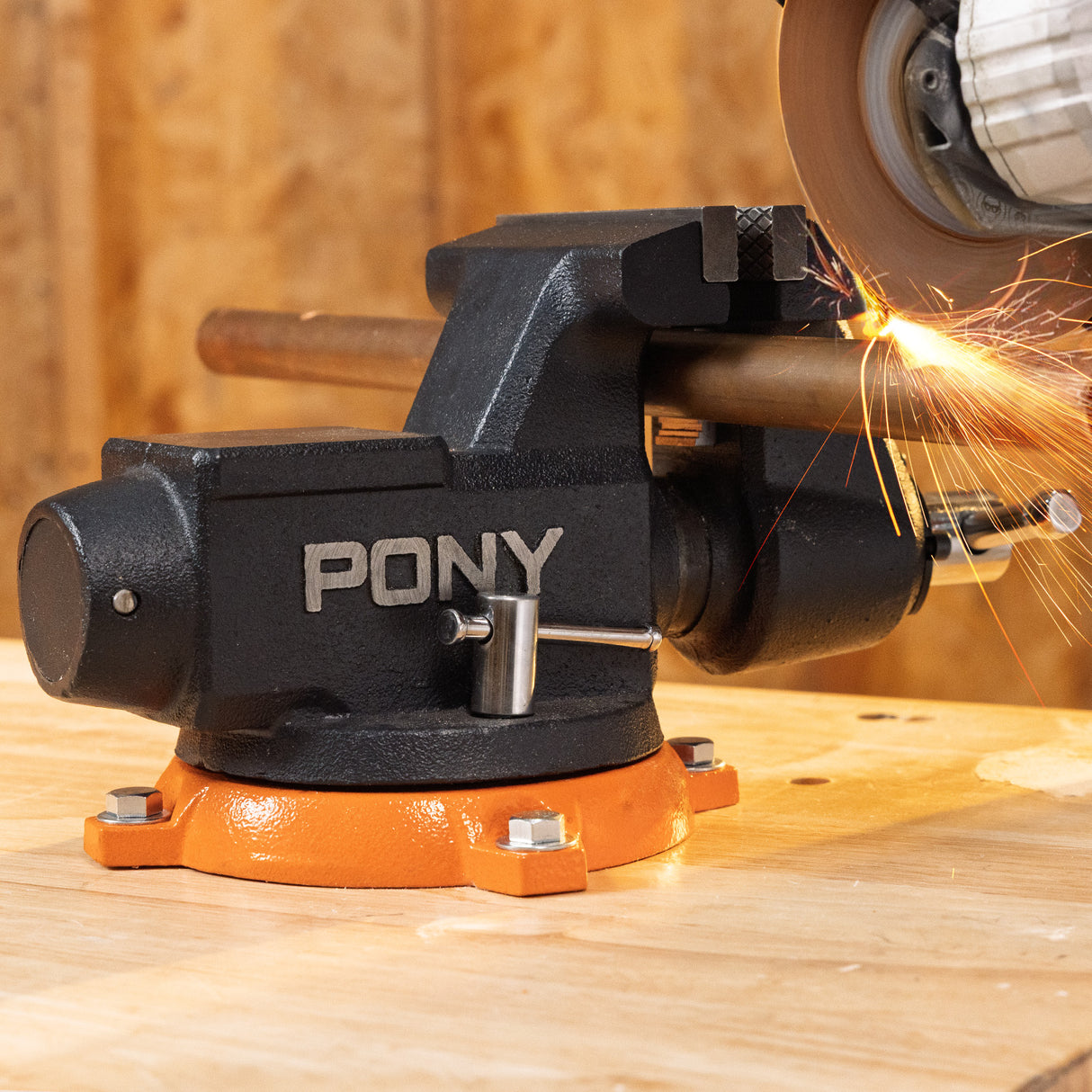 Pony angle grinder in action on a wooden surface with sparks flying.