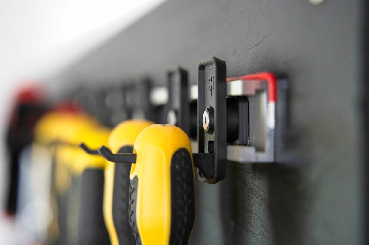 Three black Superhooks Nimble Hooks on a white background