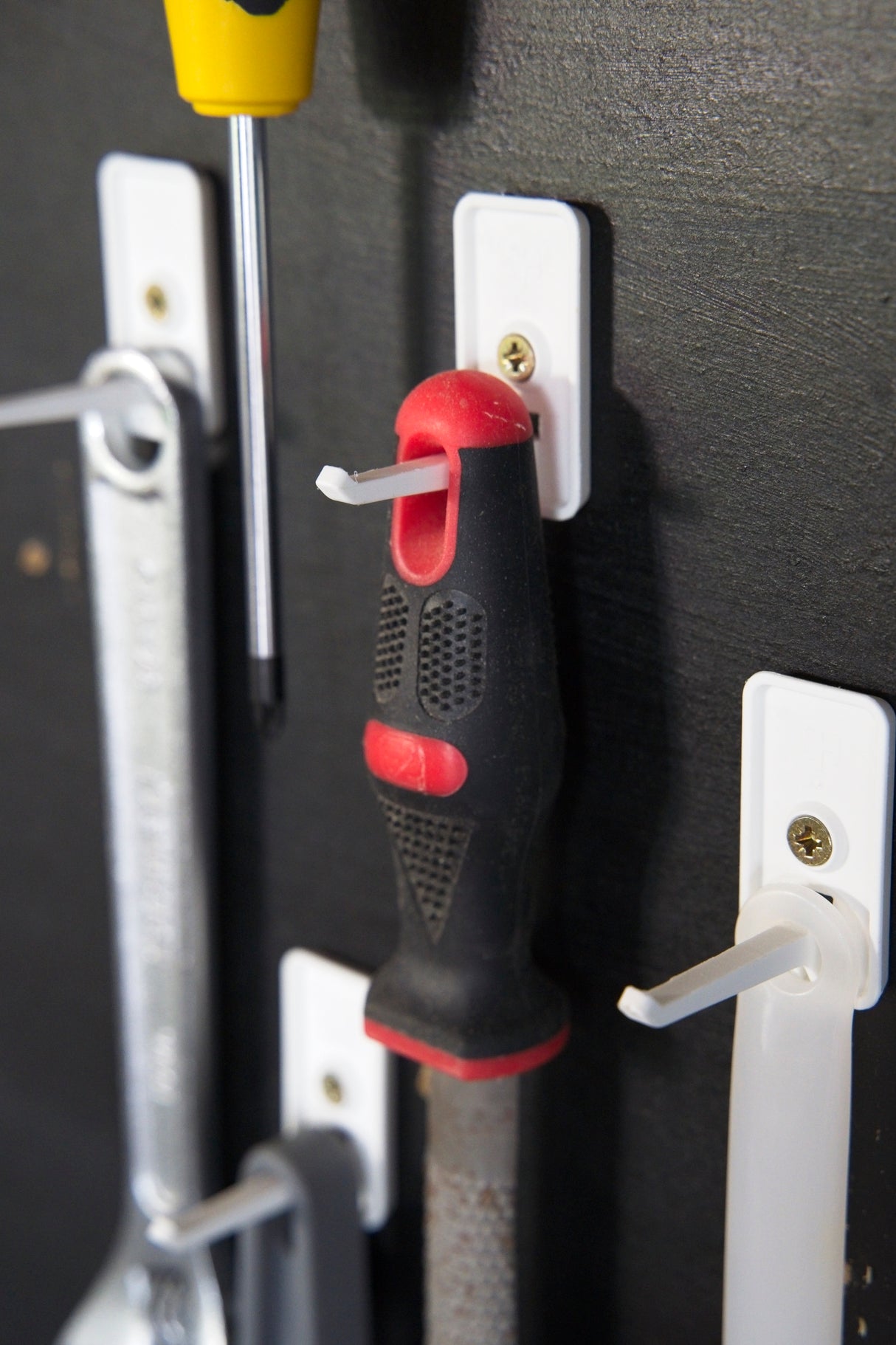 Three white Superhooks Nimble Hook hanging on a timber wall
