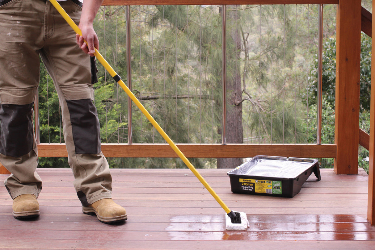 UniPro 230mm Sheepskin Decking Applicator Pad with Extension Pole in use on timber deck