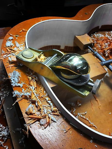 Luban Bronze Knuckle Cap Apron Hand Plane in use on wooden surface with shavings