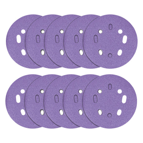 Multiple purple sanding discs with holes on a white background