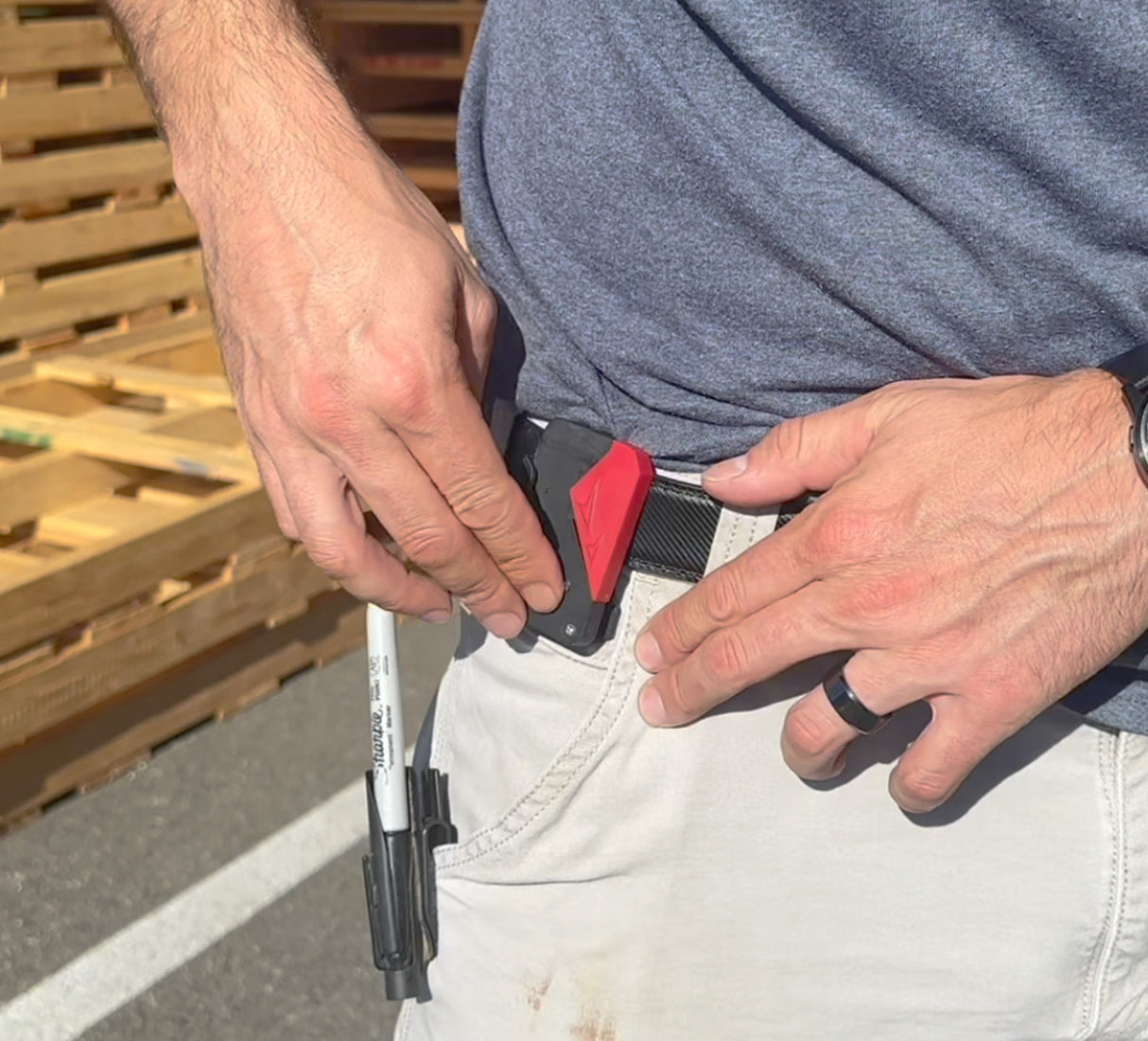 Person with a belt attaching the FastCap tape measure lock 
