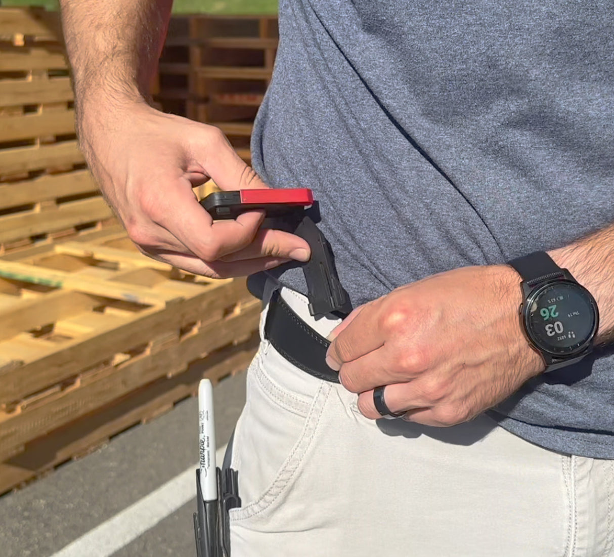 Person with a belt attaching the FastCap tape measure lock 
