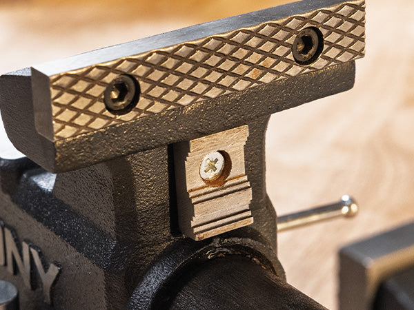 Close-up of a black metal vise with wooden handle
